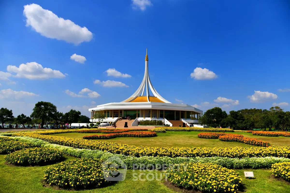 Stunning architectural building surrounded by vibrant gardens under a clear blue sky.