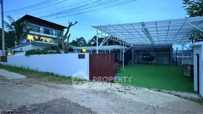 Modern two-story house with spacious outdoor area and covered parking, ideal for family living.