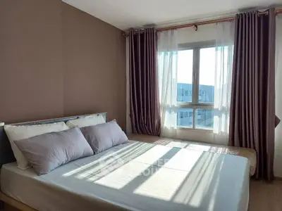 Cozy bedroom with large window and elegant curtains, perfect for natural light lovers.