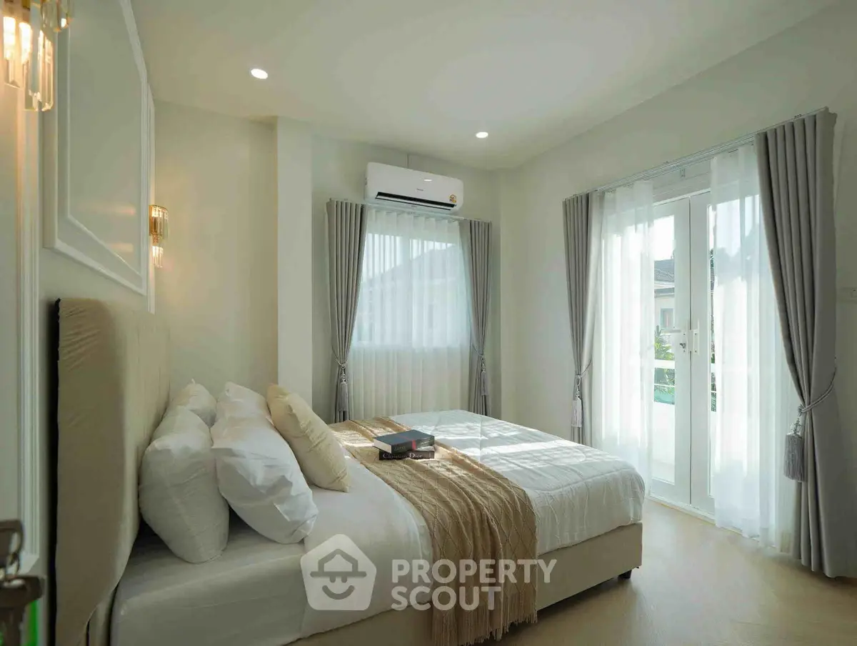 Bright and airy bedroom with large windows and modern decor, perfect for relaxation.