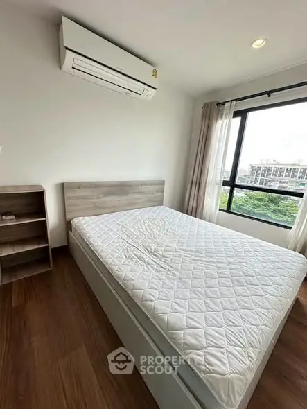 Modern bedroom with large window and air conditioning, featuring a comfortable bed and wooden flooring.
