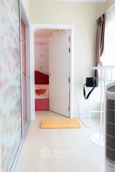 Bright and cozy interior with open door leading to a colorful bedroom, featuring modern decor and natural light.