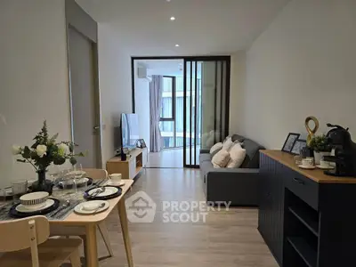 Modern living room with elegant dining area and cozy seating, featuring stylish decor and natural light.