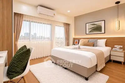 Modern bedroom with large windows and stylish decor in a cozy apartment.