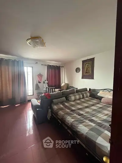Spacious bedroom with large windows and cozy seating area, perfect for relaxation.