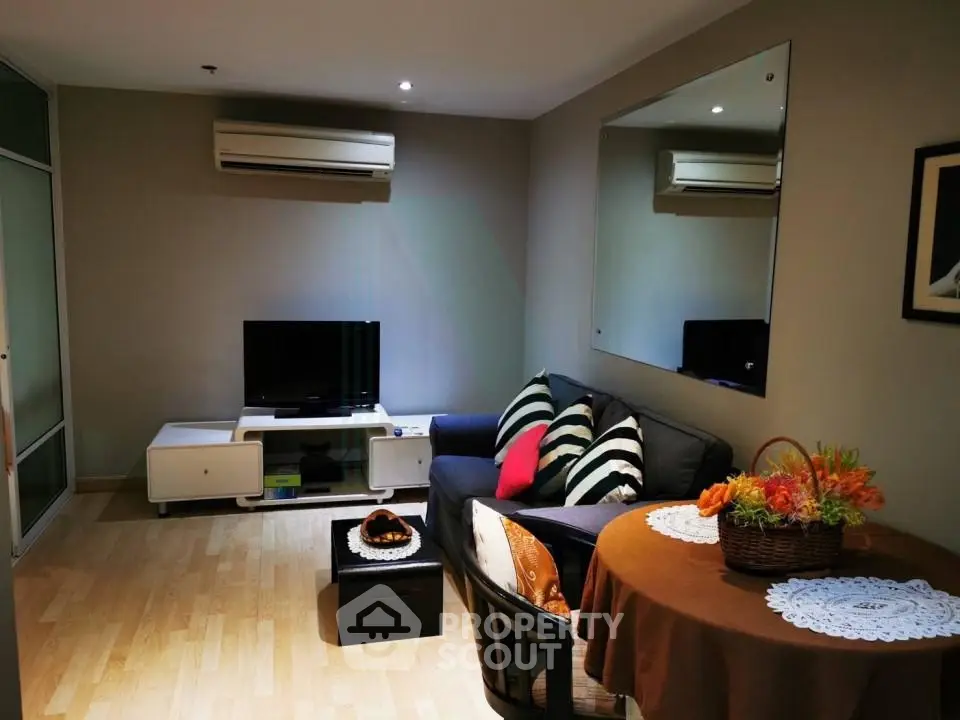 Cozy living room with modern decor and air conditioning, perfect for relaxation.