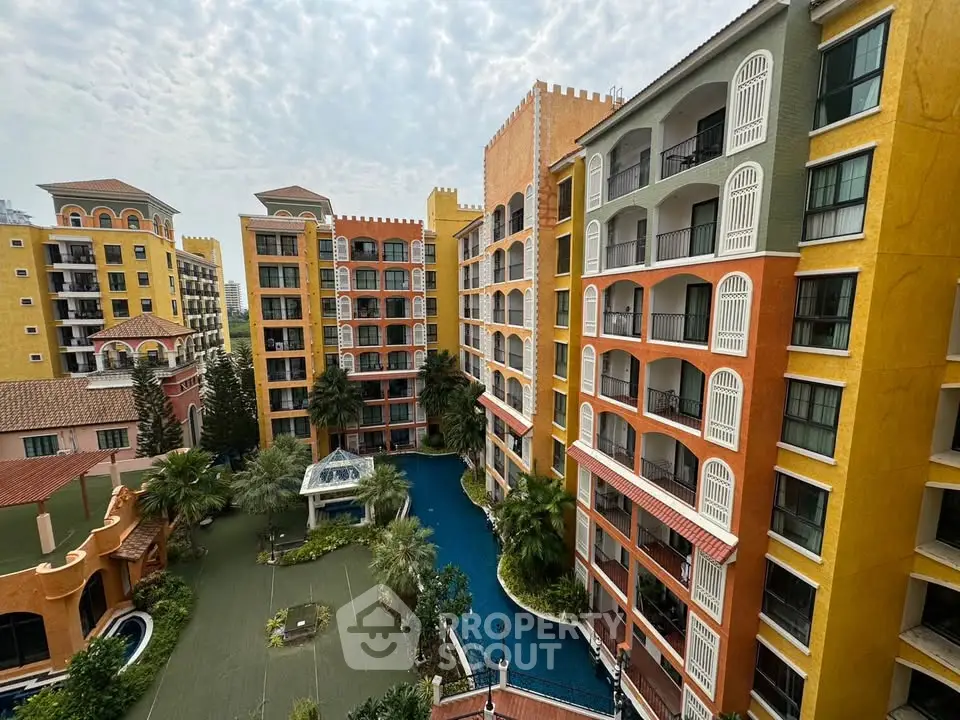 Stunning view of colorful apartment complex with lush landscaping and pool.