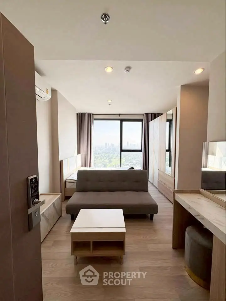 Modern living room with city view, featuring sleek furniture and natural light.