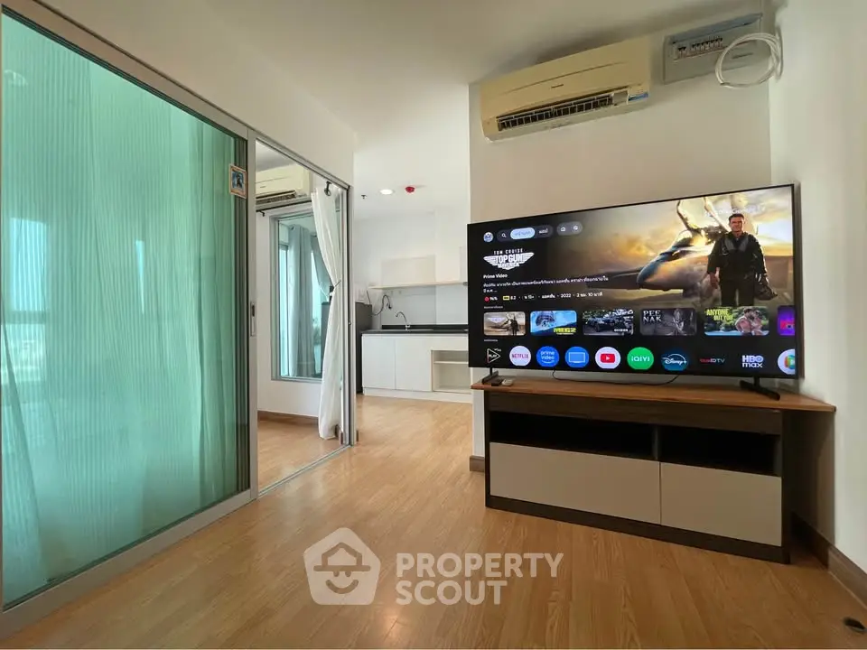 Modern living room with large TV and open kitchen in stylish apartment