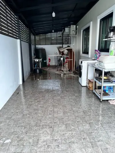 Covered outdoor utility area with washing machine and storage space.