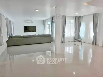 Spacious modern living room with large windows and elegant curtains