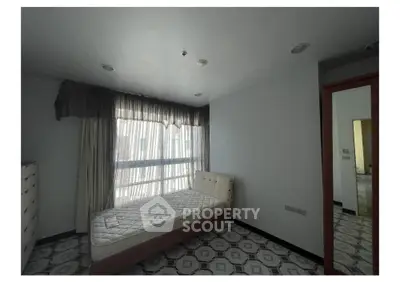 Spacious bedroom with large window and elegant flooring in modern apartment.