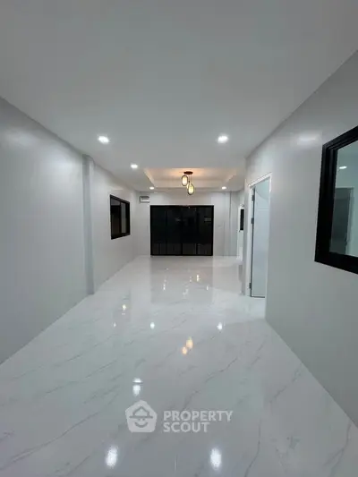 Spacious modern living room with sleek marble flooring and elegant lighting, perfect for contemporary living.