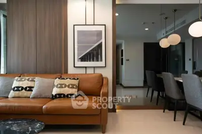 Modern living room with stylish decor and dining area in luxury apartment.