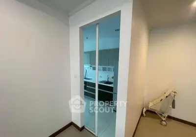Modern kitchen entrance with sleek design and stroller in hallway, showcasing minimalist style.