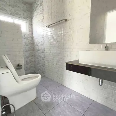 Modern bathroom with sleek fixtures and white tiled walls