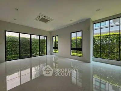 Spacious modern living room with large windows and garden view, perfect for natural light lovers.
