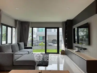 Spacious modern living room with large windows and sleek furniture