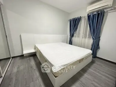 Modern bedroom with sleek design, featuring a comfortable bed, stylish curtains, and air conditioning.