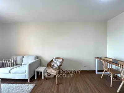 Spacious living room with modern furniture and wooden flooring, perfect for relaxation and work-from-home setup.