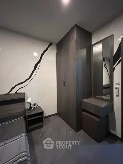 Modern bedroom with sleek design and stylish decor, featuring a large wardrobe and elegant wall patterns.