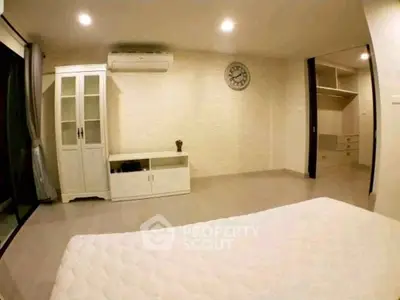 Spacious bedroom with modern decor and ample storage in a stylish apartment.