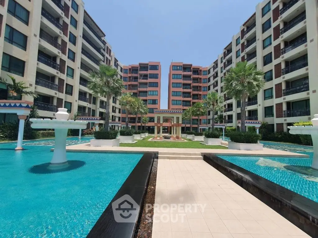 Luxurious apartment complex with stunning pool and landscaped garden view.