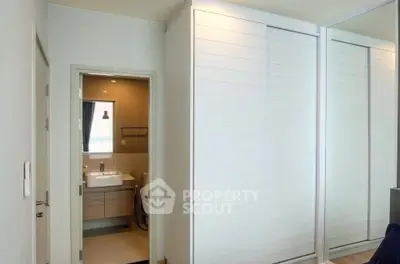 Modern bathroom with sleek design and mirrored closet doors in a contemporary apartment.