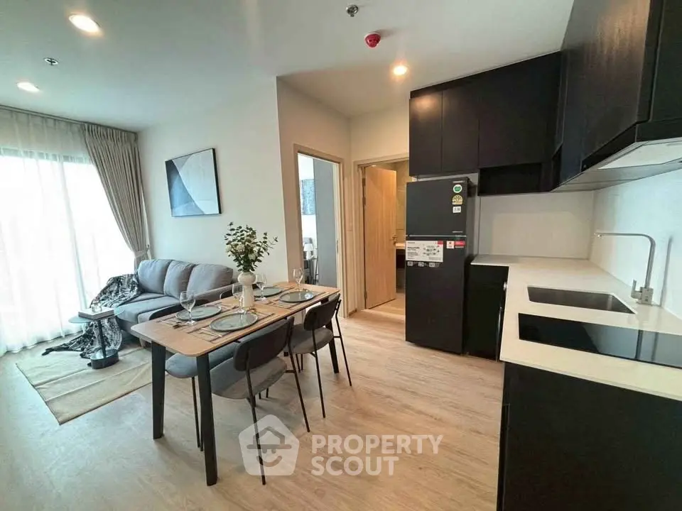 Modern open-plan living room and kitchen with stylish decor and natural light.