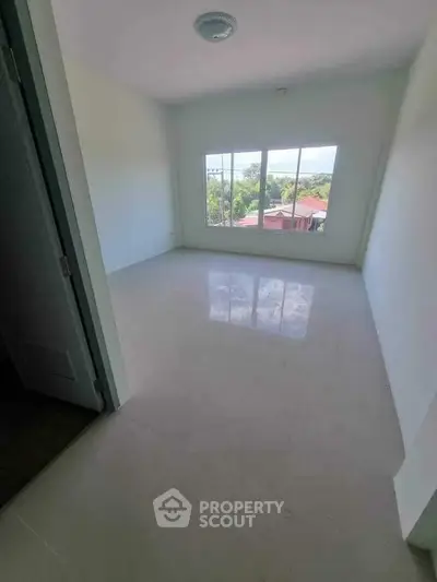 Spacious empty room with large window and scenic view, perfect for customization.