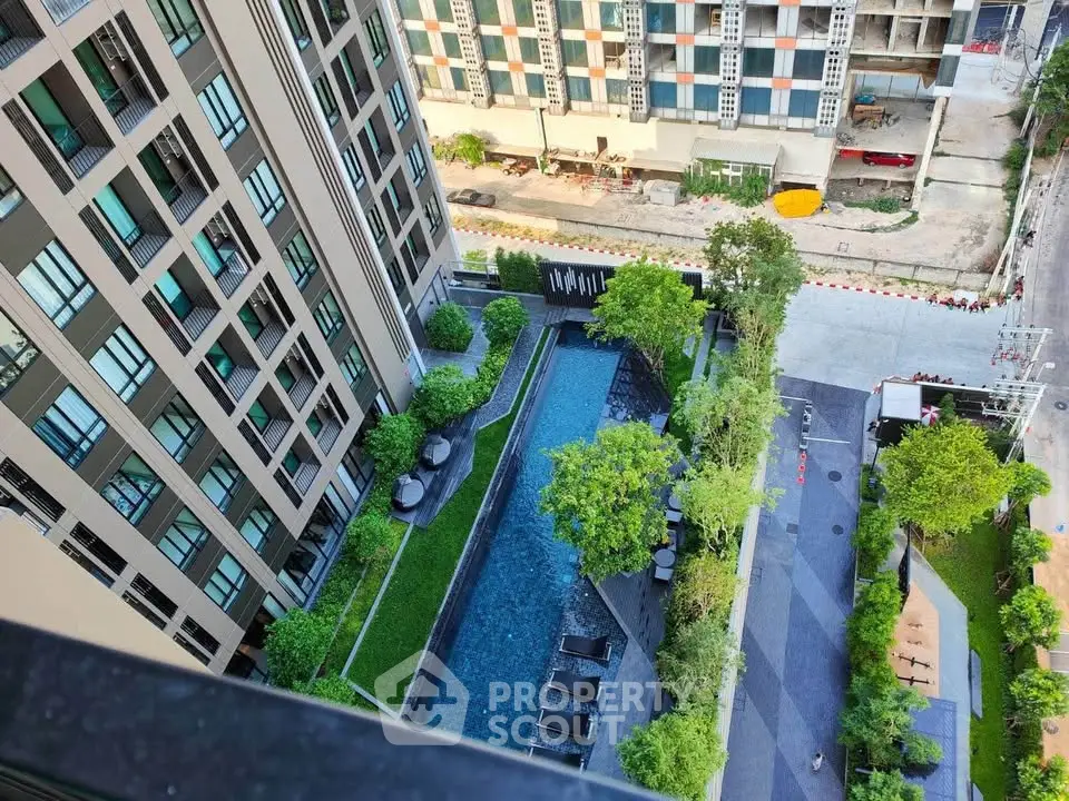 Stunning aerial view of modern apartment complex with lush greenery and inviting swimming pool.