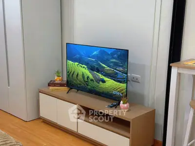 Modern living room with sleek TV setup and stylish wooden furniture.