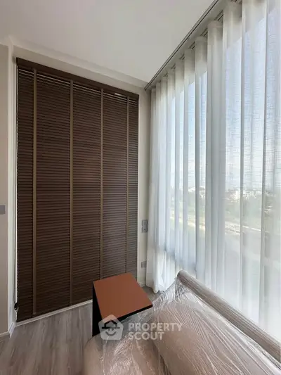 Modern living room with large windows and stylish blinds, offering a bright and airy atmosphere.