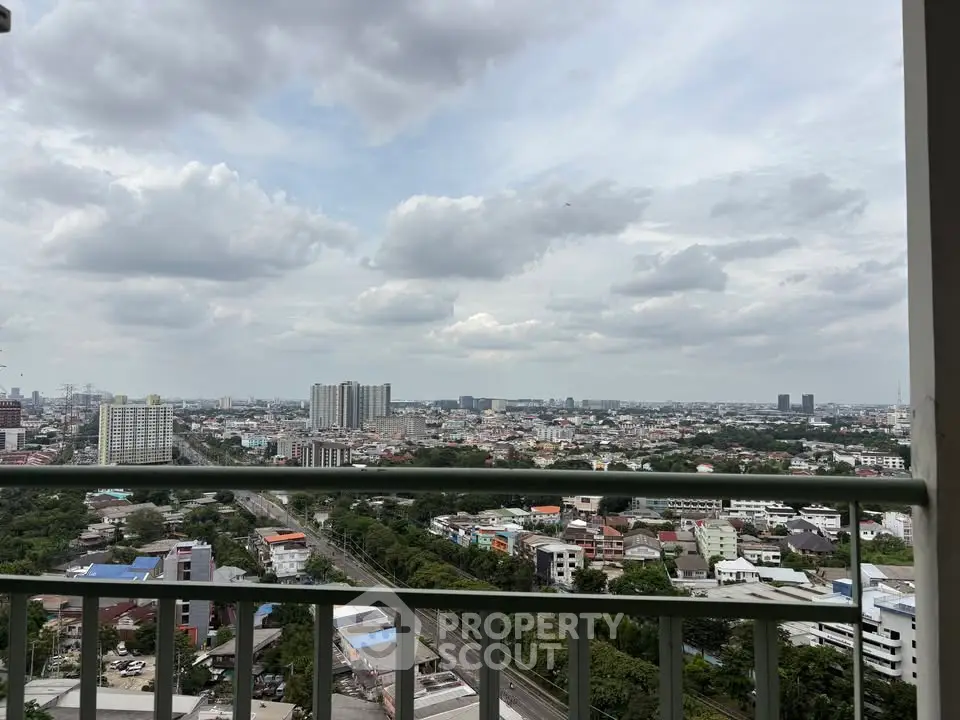 Stunning cityscape view from a high-rise balcony, showcasing urban skyline and lush greenery.