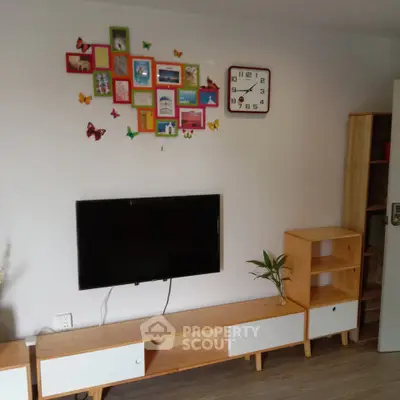 Charming living room with modern TV setup and colorful wall decor.