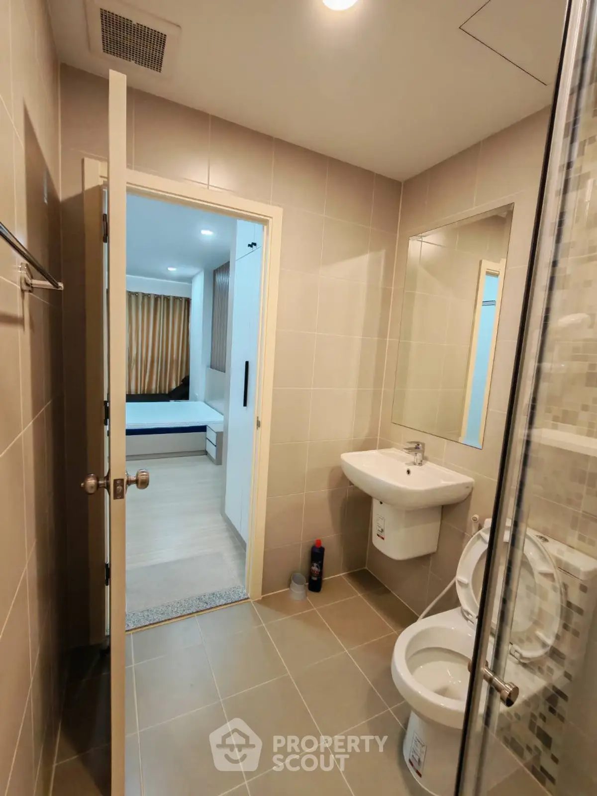 Modern bathroom with sleek fixtures and view into a cozy bedroom