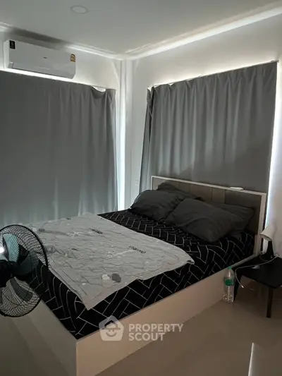 Cozy bedroom with modern decor and air conditioning, featuring dark curtains and sleek furnishings.