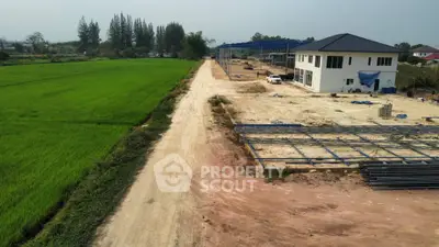 Expansive real estate development site with new construction and lush green fields.