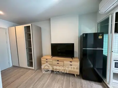 Modern living room with sleek furniture and large fridge, perfect for urban living.
