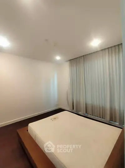 Spacious bedroom with modern design and large windows for natural light.