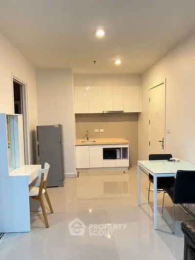 Modern open-layout kitchen with sleek white cabinets and dining area
