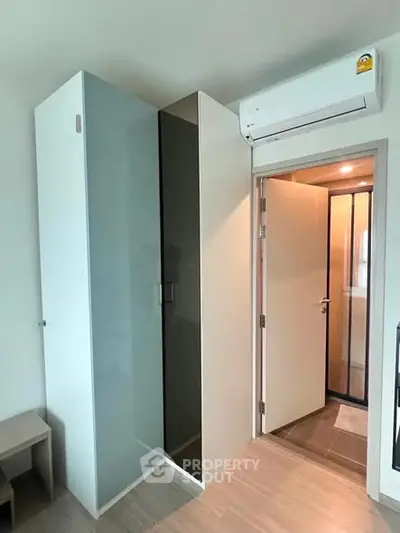 Modern apartment interior with sleek closet and air conditioning unit