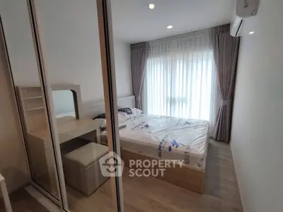 Modern bedroom with mirrored closet and natural light