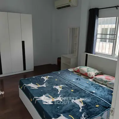 Cozy bedroom with modern furniture and large window for natural light.