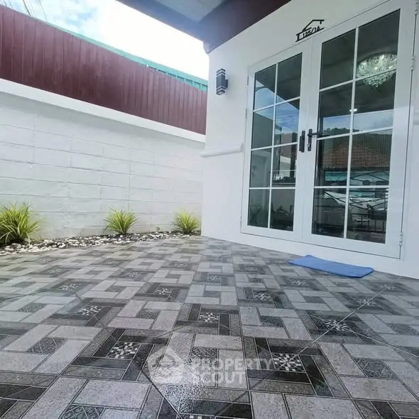 Modern patio with stylish tile flooring and glass doors in a contemporary home.