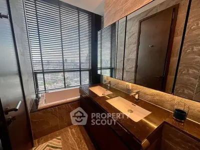 Luxurious bathroom with dual sinks and city view from large window.