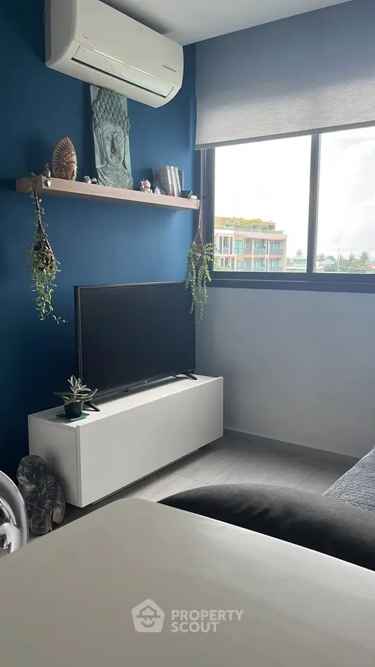 Chic modern bedroom with a serene blue color scheme, featuring a sleek low-profile bed, stylish decor, and a large window inviting ample natural light.