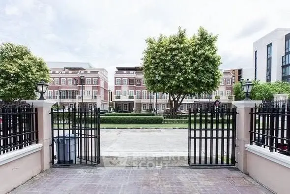 Charming townhouse complex with gated entrance and lush greenery