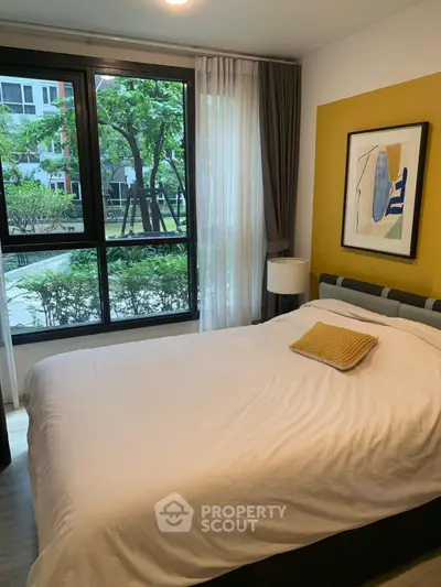 Cozy bedroom with large window and garden view in modern apartment