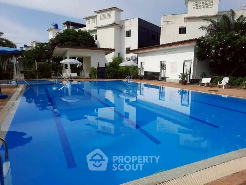 Luxurious residential pool area with pristine blue water and elegant surroundings.